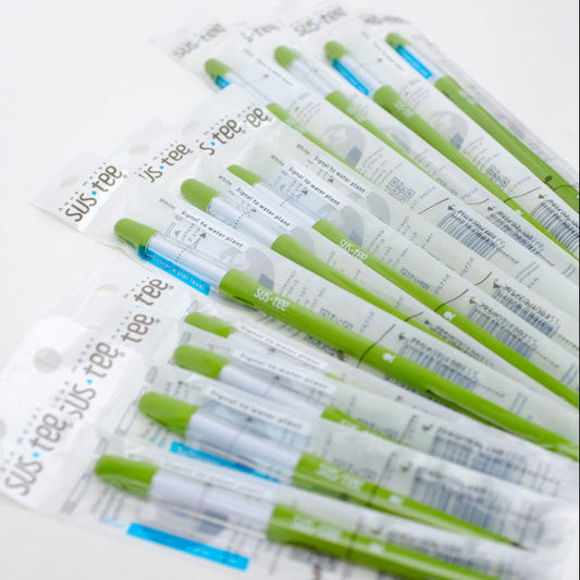 Individually wrapped Sustee watering measuring sticks in white and green colors, laid out on a white surface.